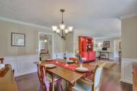 This view demonstrates the access to the kitchen and the front room with large windows overlooking the front porch.