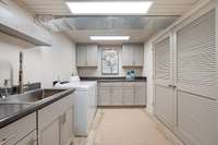 Nicely designed laundry room with sink and plenty of storage