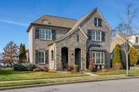 Timeless French Country Tudor with arched entry, covered front porch, wood shutters and sidewalk streets. You've arrived!