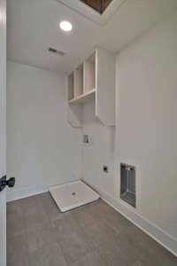 2nd floor laundry room is large with built-in shelving for convenience.