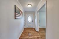 Entry foyer complete with hardwood flooring.