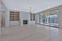 Family Room features Arcustone Fireplace and Custom Built Ins. Hidden Panel for Electronics above Fireplace