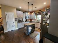 The kitchen features granite countertops and an island perfect for meal preparation, sleek cabinets, stylish backsplash, and room to cook and entertain. Custom designed sink fit for a chef.