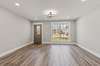 Large living space with easy to clean LVT flooring and modern fixtures.