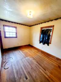 Bedroom 2 has sand and finish hardwood floors and 2 windows