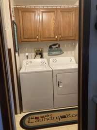 The laundry room is spacious and features upper cabinetry for your storage needs -- everyone loves a laundry "room"!