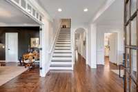 Dark wood floors, crisp white paint, & transom windows allow natural light to flood this space.