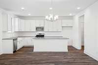 The kitchen features timeless white cabinetry, stunning quartz countertops and a stylish hex tile backsplash.