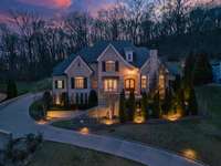 Specialty landscape and hardscape lighting beautifully illuminates the property amidst the night sky.