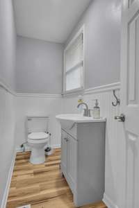 Renovated Half bath with bead board accent walls, updated vanity, and floors.