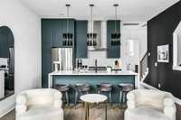 The intensity of the property's monochromatic color palette is brazenly interrupted by the deep teal colorway of the kitchen's ceiling-height cabinetry. This delicious pop of color adds a sense of comfort and warmth to your guests during their stay.