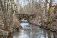 Become at peace as you drive over the stone bridge & tranquil creek with waterfall feature.