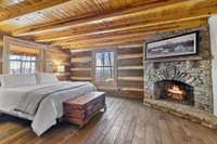 Primary bedroom on main level graced with one of the homes wood burning fireplaces.