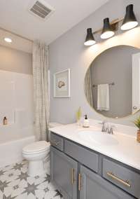 Hall bath upstairs! Different options for shower or tub layout. Are you a fan of the navy blue cabinet?