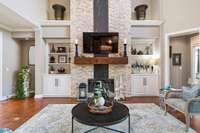 Beatuiful built ins flank the gas fireplace which features a wood beam mantle, stone and granite.