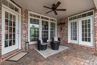 The covered back porch boasts a ceiling fan, wall heaters, paver flooring and a great view of the backyard oasis!