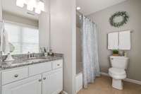 The ensuite bathroom has granite counters and lots of natural light.