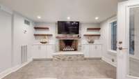 Gorgeous gas spheres fireplace with built in cabinetry and waterfall granite.