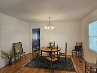 THE DINING ROOM FROM THE FRONT DOOR,...NOTICE THE CENTRAL AIR REGISTERS ARE ON THE FLOOR WHICH IS MUCH EASIER ON THE HEAT AND AIR UNIT TO RAISE OR DROP THE TEMPERATURE.