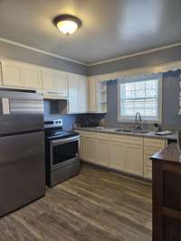 A WELL SUITED KITCHEN ALSO WITH NEW FLOORING AND FRESH PAINT