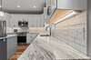 Beautiful marbled leather counter tops and subway tile back splash and under cabinet lighting.