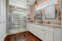 Double vanities, a wash closet and shower with double shower heads