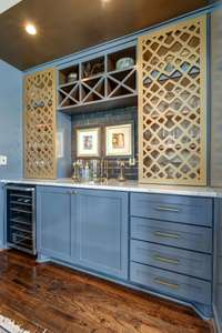 The dedicated bar area features custom designed bar cabinetry including a wine refrigerator