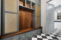 Mudroom off the garage is finished off with metal cabinet door inserts and oversized gold pulls. Almost too nice to drop your muddy shoes!