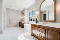 Primary bath with furniture style vanities, custom mirrors, high-end hardware and marble floors with zero entry to shower