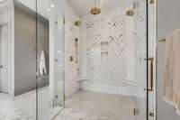 Must see the marble detail in the primary bath with zero-entry shower and multiple shower and rainheads. Gorgeous knurled brass oversize door pulls on the frameless glass doors.