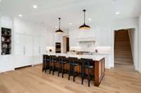 Builder thought of everything for this kitchen! Note the hidden pantry doors next to the cabinet-front refrigerator to the left of the island