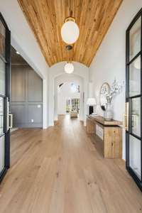 Double doors lead to gorgeous entry hall with barrel ceiling finished in pecky cypress tongue and groove