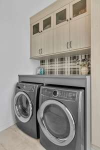 The fully renovated laundry room has wonderful storage and is decoratively designed.