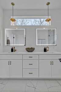 The primary bath offers double vanities with plenty of storage, smart mirrors and wonderful natural light.