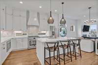 Sleek white cabinetry and stunning quartz countertops in this chef's kitchen