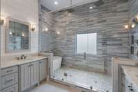 Primary bathroom has a large tub/shower combination, with dual vanities and heated marble flooring!