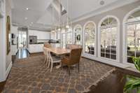 This beautiful extra dining space with stylish pendant lighting is flooded with natural light all times of the day from skylight & wall-to-wall arched windows! A french door leads to the large covered back patio, allowing for seamless entertaining.