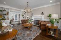 The family room to the right of foyer featuring custom built shelving/cabinetry & wood-burning fireplace flows into the kitchen dining area through another large cased opening