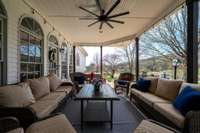 An expansive covered patio is right off the kitchen / breakfast area & encourages outdoor relaxation & al fresco dining. This outdoor entertainment area is adorned with bistro string lighting, sconce lighting, and a large ceiling fan.