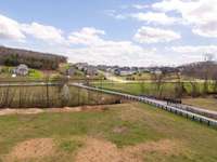 Upon entering the property, a lovely land bridge over the stream adds an element of charm this beautiful home