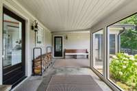 The back area screened-in porch that leads to a small dog fully fenced area/fire pit.