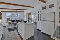 Check out the "Big Chill" refrigerator. The hardwood flooring, possibly the original (no way to know for certain) runs all throughout the first floor for a wonderful architectural contrast with the light colored walls.