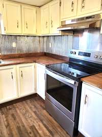 Fresh painted cabinets, new custom butcher block countertops and new flooring plus a stainless steel stove.