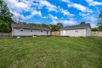 A overview of fenced back yard, house and 2 car garage