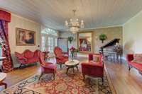 The grand living room, part of the home's original 1802 construction, definitely has the WOW factor. Wide and spacious, it features hardwood flooring, reclaimed-wood panels, and a Palladian transom window above the front entrance.