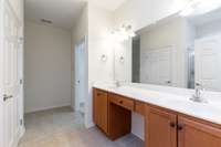 Primary Bath with double vanities, linen closet, and walk-in shower.