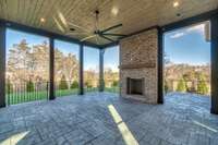 View of Covered Outdoor Living area with wood-burning fireplace that overlooks Pool and Spa that is under construction - completion July 1st, 2024