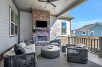 The covered side porch and adjacent courtyard is the perfect place to unwind and relax by the fireplace