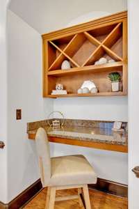 Tucked inside the dining room is a custom-built butler's pantry boasting built-in shelving and a floating granite counter, versatile enough to serve as a desk.