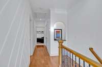 The upstairs area truly shines as a showcase, featuring a chic wood trim accent wall, illuminated art niche, stunning hardwood floors, and a new HVAC system .The owner's suite is straight down this inviting hallway.